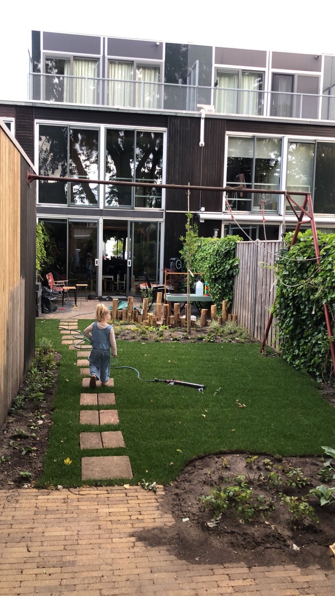 Kindje loopt over stapstenen door een natuurlijke achtertuin