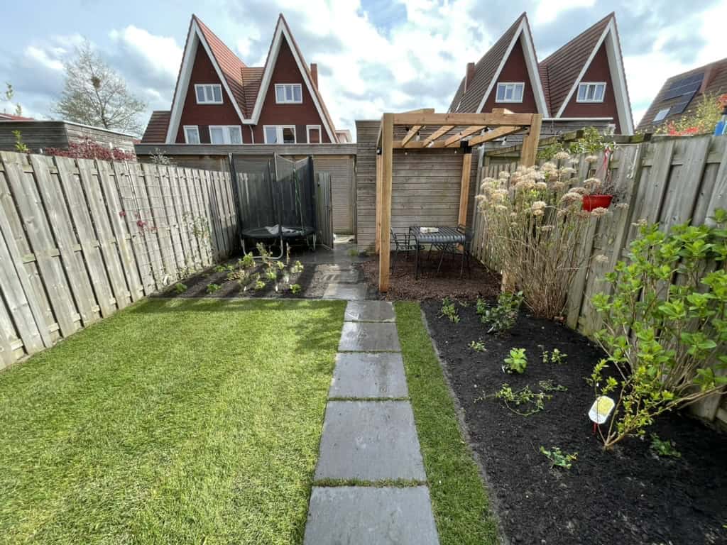Tuin met gras, traptrede en bloemenborder