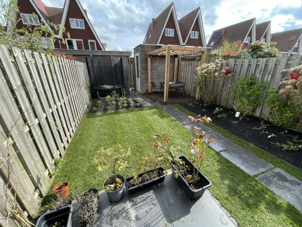 Tuin met verhoogde plantenbakken en natuurlijke bestrating