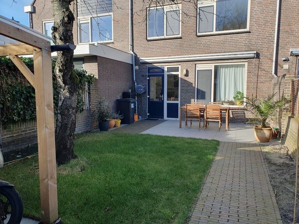 Achtertuin voor de verbouwing met gazon en terras