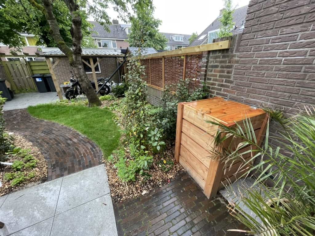 Houten compostbak in een groene tuin