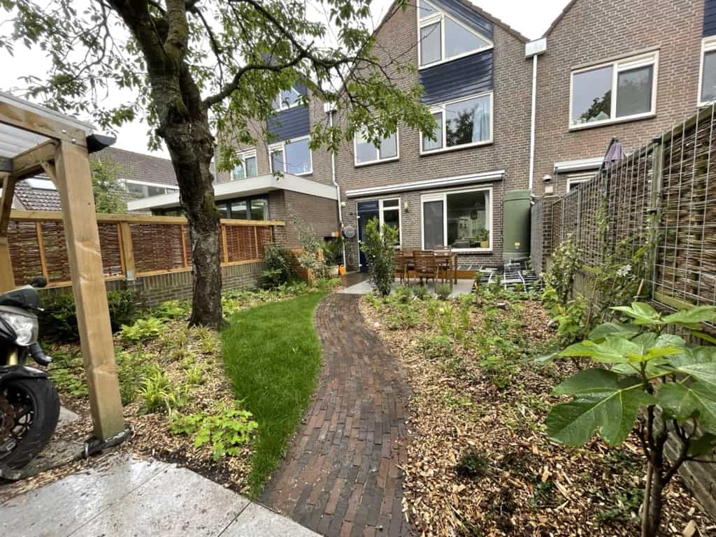 Gebogen bakstenen pad door groene borders