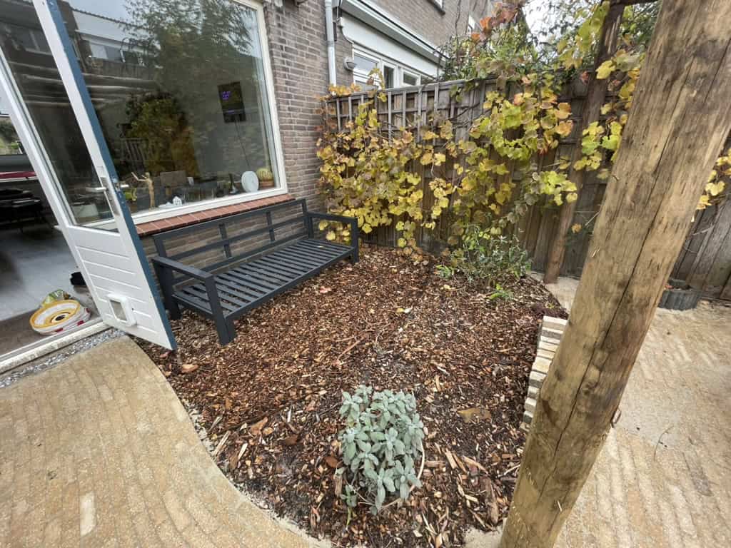 Zitbank met klimop en natuurlijke bestrating