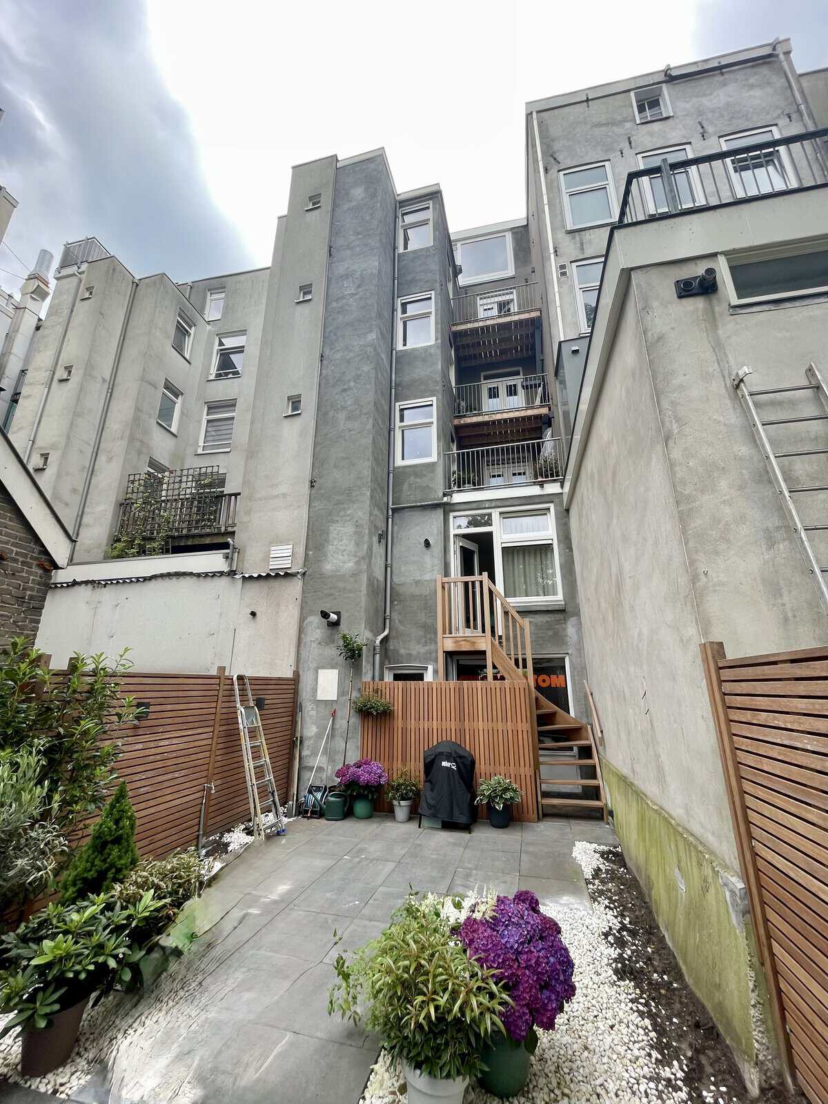 Smalle stadstuin tegen hoog appartementsgebouw